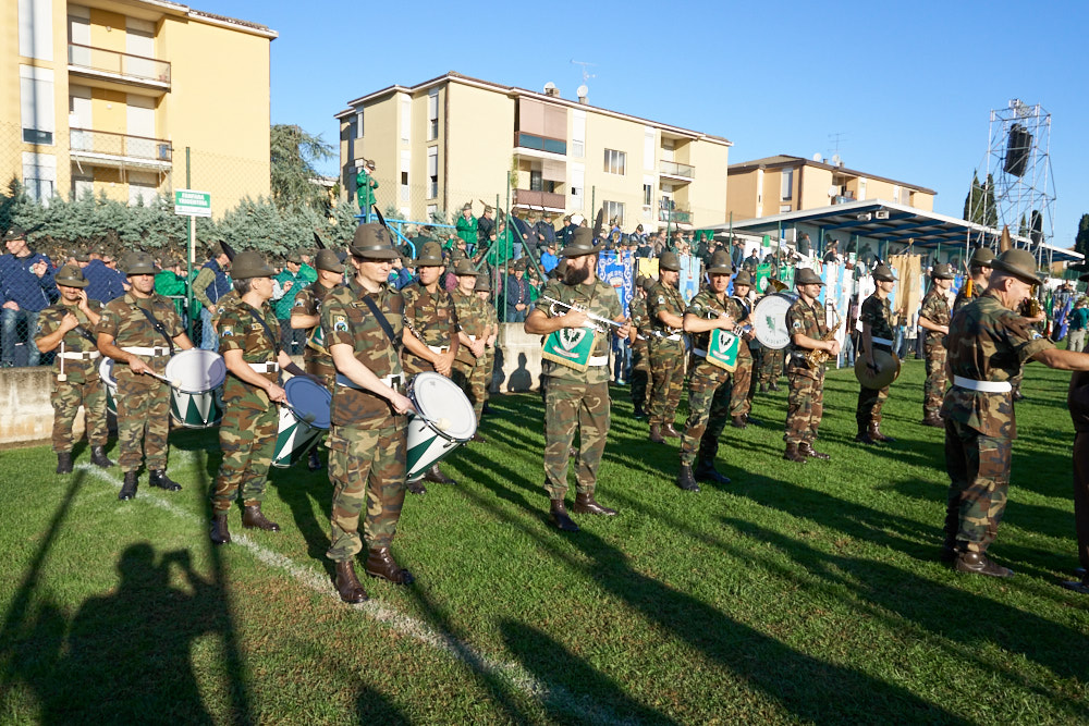 Gruppo di militari in uniforme suona strumenti musicali su un prato in un luogo pubblico