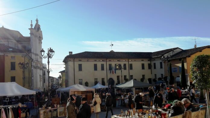Bancarelle e visitatori del Mercantico dell'antiquariato in piazza a Lonato del Garda