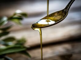 Olio extravergine d'oliva versato su un cucchiaio alla festa olio Torri.