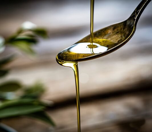Olio extravergine d'oliva versato su un cucchiaio alla festa olio Torri.