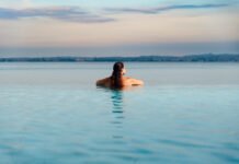 Donna rilassata in piscina a sfioro con vista sul lago di Garda a Desenzano