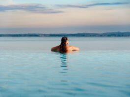 Donna rilassata in piscina a sfioro con vista sul lago di Garda a Desenzano