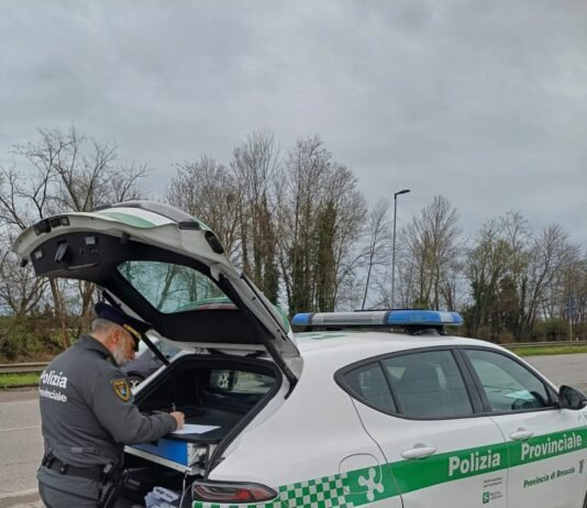 Agente della Polizia Provinciale di Brescia con auto di servizio sulla tangenziale Sud