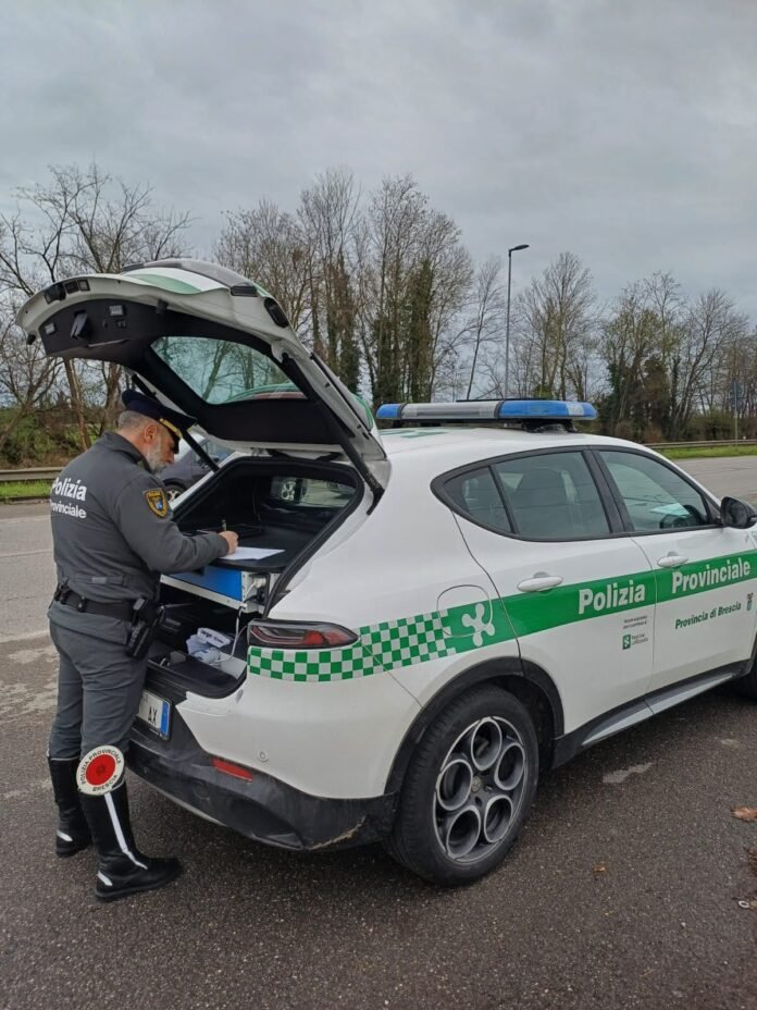 Agente della Polizia Provinciale di Brescia con auto di servizio sulla tangenziale Sud