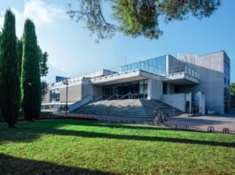 Terme di Sirmione, Therapy District apre anche la domenica da maggio a dicembre Edificio moderno delle Terme di Sirmione con area verde e bicicletta.