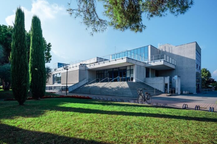 Edificio moderno delle Terme di Sirmione con area verde e bicicletta.