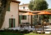 Area esterna con tavoli e ombrelloni arancioni al beach club Punta San Vigilio