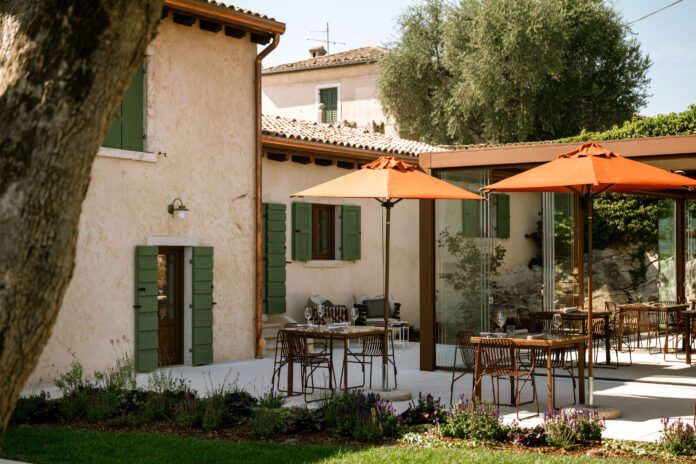 Area esterna con tavoli e ombrelloni arancioni al beach club Punta San Vigilio