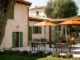Area esterna con tavoli e ombrelloni arancioni al beach club Punta San Vigilio
