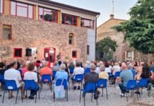 Pubblico seduto all'aperto durante evento culturale a Montichiari estate Monteclarense.