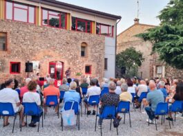 Pubblico seduto all'aperto durante evento culturale a Montichiari estate Monteclarense.