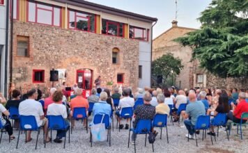 Pubblico seduto all'aperto durante evento culturale a Montichiari estate Monteclarense.