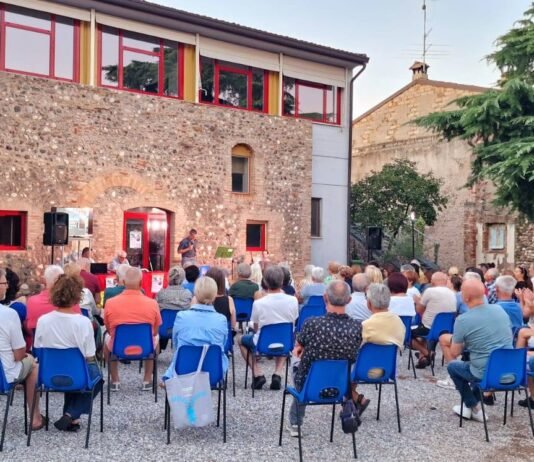 Pubblico seduto all'aperto durante evento culturale a Montichiari estate Monteclarense.