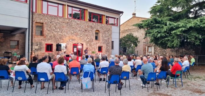 Pubblico seduto all'aperto durante evento culturale a Montichiari estate Monteclarense.