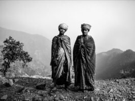Mostra fotografica sul Nepal contemporaneo alla Rocca di Lonato del Garda Due uomini nepalesi in abiti tradizionali con montagne sullo sfondo.