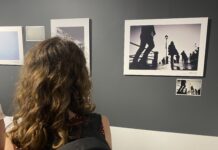 Una visitatrice osserva le fotografie esposte nella mostra WOUND | FERITA