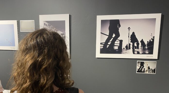 Una visitatrice osserva le fotografie esposte nella mostra WOUND | FERITA