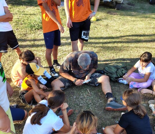 Istruttore mostra tecniche di sopravvivenza ai bambini al camp estivo Rifugio Granata.