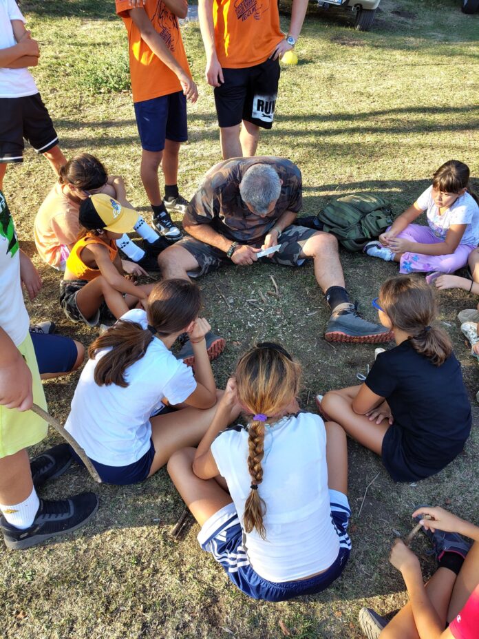 Istruttore mostra tecniche di sopravvivenza ai bambini al camp estivo Rifugio Granata.