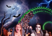 Persone in costume su montagne russe durante Halloween a Gardaland.