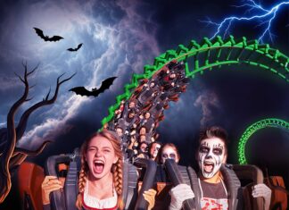 Persone in costume su montagne russe durante Halloween a Gardaland.
