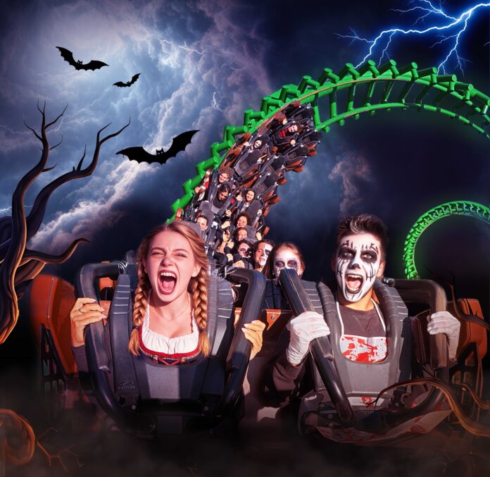 Persone in costume su montagne russe durante Halloween a Gardaland.