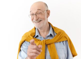 Uomo anziano sorridente con i capelli bianchi, paziente di implantologia All On 4