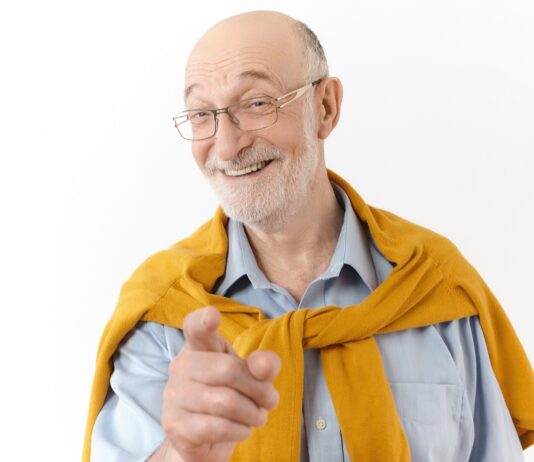 Uomo anziano sorridente con i capelli bianchi, paziente di implantologia All On 4