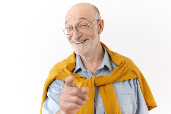 Uomo anziano sorridente con i capelli bianchi, paziente di implantologia All On 4