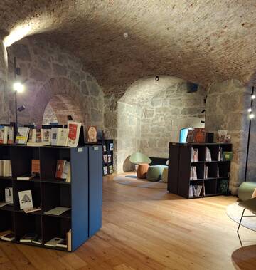 Biblioteca Nago-Torbole riapre martedì 20 ottobre al Forte di Nago 1 Interno di una stanza con scaffali e libri nel nuovo Polo culturale al Forte di Nago