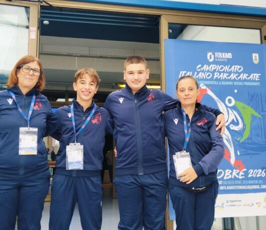 Atleti del Garda Karate Team davanti al pannello del Campionato Italiano Parakarate al Palasport di Marcon