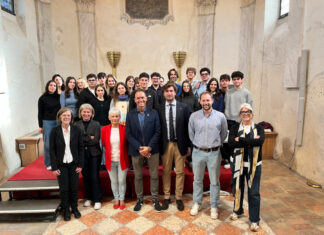 Capitale della Cultura 2029: gli studenti dell’Università di Trento progettano nuove idee per Bardolino Un gruppo di giovani sorride in una sala antica davanti a un palco rosso