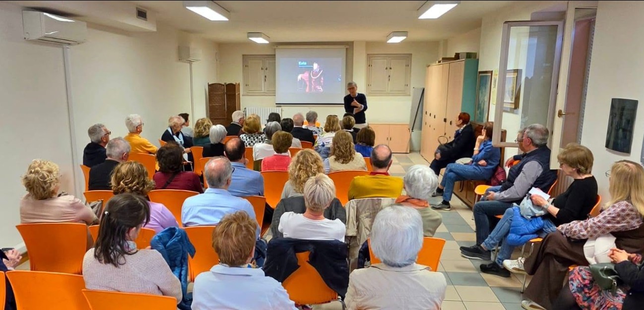 Collodi e Pinocchio alla Casa Bianca di Montichiari giovedì 22 ottobre 2 Scena di incontro in aula con persone sedute e un relatore davanti a una proiezione