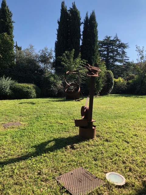Concesio, alla Collezione Paolo VI due mostre fino al 19 dicembre 1 Scultura metallica su prato con alberi in fondo sotto sole chiaro