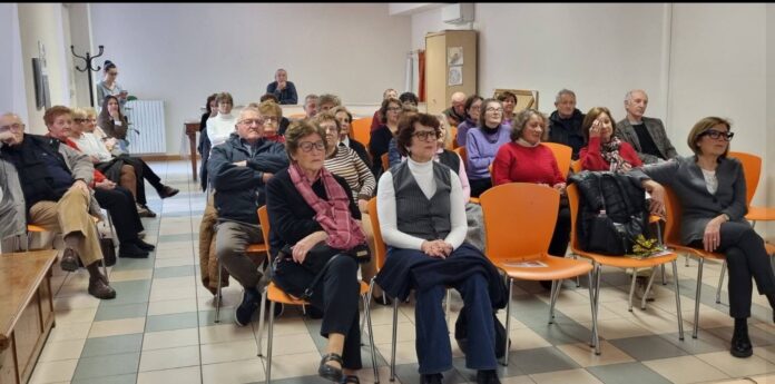 Incontro con il pubblico in una sala con sedie arancioni al Centro Casa Bianca di Montichiari
