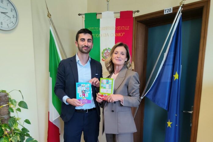Uomini e donne in aula mostrano libri accanto a bandiere e finestre