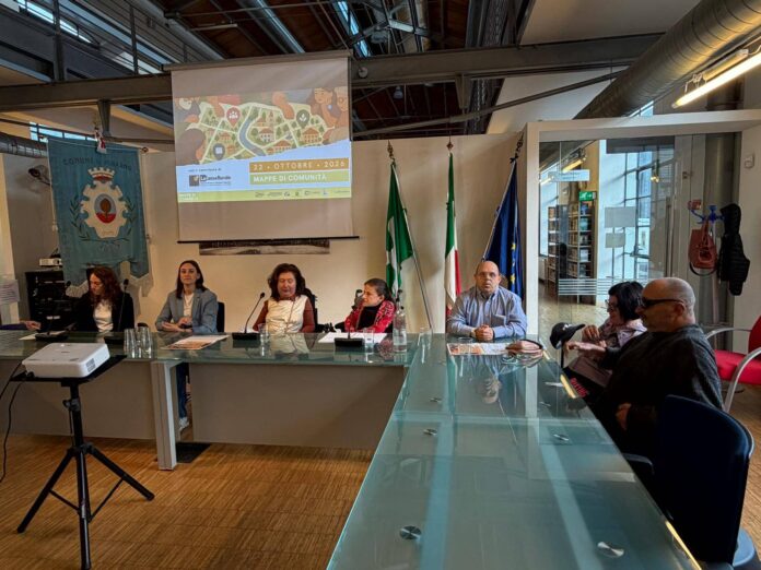 Sala riunioni con mappa interattiva e persone sedute davanti a un proiettore