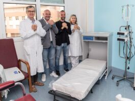 Quattro letti per gli accompagnatori agli Spedali Civili di Brescia Quattro persone sorridono in una stanza con letti e apparecchiature mediche presso il reparto di Oncologia degli Spedali Civi