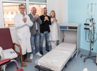 Quattro letti per gli accompagnatori agli Spedali Civili di Brescia Quattro persone sorridono in una stanza con letti e apparecchiature mediche presso il reparto di Oncologia degli Spedali Civi