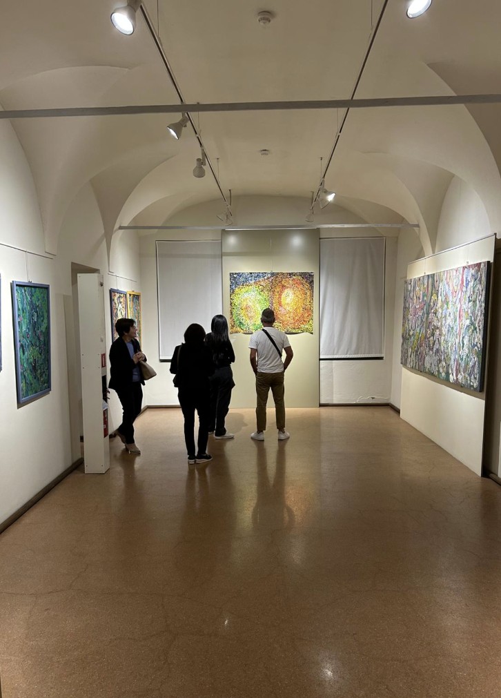 Renzo Troglio espone al Museo Lechi di Montichiari fino all'8 novembre 1 Un gruppo di persone cammina in un corridoio di un museo, con opere d'arte appese alle pareti e luce dall'alto.