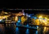 Sirmione di notte, con gli edifici illuminati e le barche lungo la riva