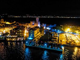 Sirmione di notte, con gli edifici illuminati e le barche lungo la riva