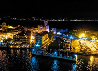 Catullo in Love 2026 a Sirmione: tre serate di libri e racconti all’Hotel Catullo Sirmione di notte, con gli edifici illuminati e le barche lungo la riva
