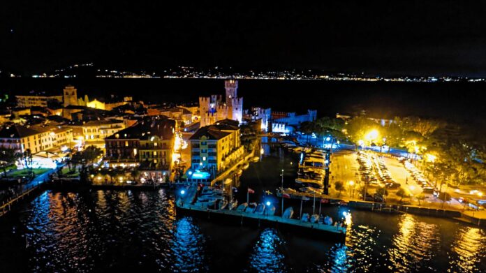 Sirmione di notte, con gli edifici illuminati e le barche lungo la riva
